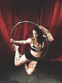 a woman doing a hoop on a red curtain